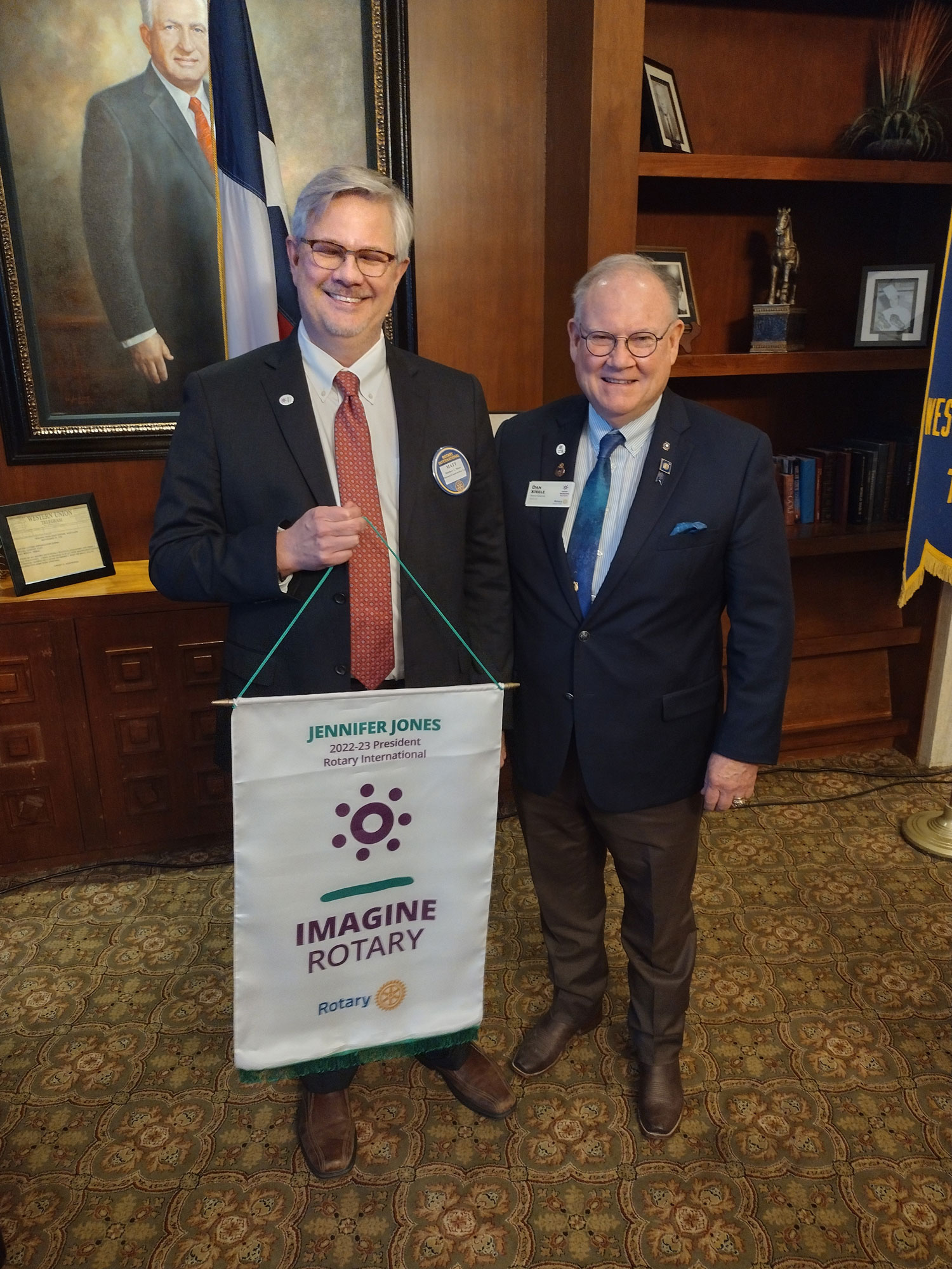 shackelford attorney Matt Motes inducted as 70th president for the western fort worth rotary club two men with recognition banner in hand both wearing suit and ties